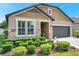 Charming home featuring stone accents, a two-car garage, and lush, manicured landscaping at 11314 American Holly Dr, Riverview, FL 33578
