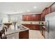 Well-lit kitchen with stainless appliances, tile floors, and a large island with granite countertops at 11314 American Holly Dr, Riverview, FL 33578