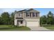 Charming two-story home featuring neutral siding, a front-facing garage, and freshly landscaped yard, offering curb appeal at 11737 Brae Way, Dade City, FL 33525