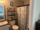Nautical themed bathroom featuring decorative shelving, patterned shower curtain, and sink at 11814 Washington St, Seffner, FL 33584