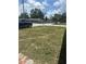 Landscaped front yard with green grass, black car, stop sign and chain link fence at 11814 Washington St, Seffner, FL 33584