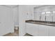 Bright bathroom boasts a double sink vanity with a dark countertop, white cabinets, and tiled flooring at 11847 Brighton Knoll Loop, Riverview, FL 33579