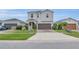 Charming two-story home featuring a two-car garage, a brick-paved driveway and lush landscaping at 11847 Brighton Knoll Loop, Riverview, FL 33579