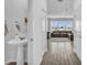 Hallway view leading into a powder room and an adjacent living room with a large sectional sofa at 11847 Brighton Knoll Loop, Riverview, FL 33579