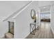 Bright hallway with wood-look tile flooring, staircase, and decorative table with a mirror at 11847 Brighton Knoll Loop, Riverview, FL 33579