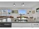 Modern kitchen with a granite island, stainless steel sink, and a view of the backyard at 11847 Brighton Knoll Loop, Riverview, FL 33579