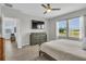 Comfortable main bedroom features a ceiling fan, a wall-mounted television, and a large window view at 11847 Brighton Knoll Loop, Riverview, FL 33579