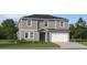 Charming two-story home with gray siding, white trim, a two-car garage, and a well-maintained lawn at 11909 Brae Way, Dade City, FL 33525