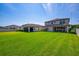 Spacious backyard with lush green grass, privacy fence, and views of the home's rear exterior at 12650 Shetland Walk Dr, Lithia, FL 33547