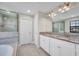 Elegant bathroom featuring double vanities, granite countertops, and a glass-enclosed shower at 12650 Shetland Walk Dr, Lithia, FL 33547