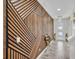Stunning entryway featuring modern wood accent wall and an elegant chandelier at 12650 Shetland Walk Dr, Lithia, FL 33547