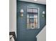 Modern hallway with blue shiplap walls, sconce lighting, and a view to the outside at 12650 Shetland Walk Dr, Lithia, FL 33547