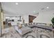 Bright and airy open-concept living room with an expansive sectional sofa that leads into a modern kitchen at 12650 Shetland Walk Dr, Lithia, FL 33547