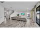Open concept living room with backyard access, large sofa, and wood-look flooring at 12650 Shetland Walk Dr, Lithia, FL 33547