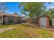 Spacious fenced backyard with a shed, screened in porch, partial grassy yard and lush green trees at 13046 Leverington St, Tampa, FL 33624