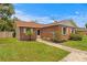 Cozy brick home with tidy landscaping, featuring white-trimmed windows and walkway at 13046 Leverington St, Tampa, FL 33624