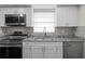 Modern kitchen featuring stainless steel appliances, granite counters, and white cabinetry at 13046 Leverington St, Tampa, FL 33624