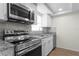 Kitchen with stainless steel appliances, granite countertops, and white cabinets at 13046 Leverington St, Tampa, FL 33624
