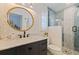 Charming bathroom featuring a stylish vanity, round mirror, and a modern glass-enclosed shower at 13168 84Th Ter, Seminole, FL 33776