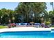 Relaxing poolside lounge area with stylish outdoor seating amidst tropical foliage at 13168 84Th Ter, Seminole, FL 33776