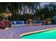 Comfortable poolside lounge area surrounded by tropical foliage, creating a serene and private outdoor retreat at 13168 84Th Ter, Seminole, FL 33776