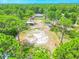 Aerial view of the property highlighting house and outbuildings nestled among trees at 15207 Taralane Ave, Brooksville, FL 34604