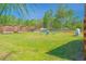 Large, grassy backyard with chairs and wooden fencing at 15207 Taralane Ave, Brooksville, FL 34604