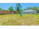 Spacious backyard with wooden fence and light blue Adirondack chairs at 15207 Taralane Ave, Brooksville, FL 34604