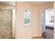 Attached bathroom with an updated, tiled shower, beige walls, and tan floor at 15207 Taralane Ave, Brooksville, FL 34604