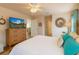 Bedroom with wood floors, a large TV and a view into other rooms at 15207 Taralane Ave, Brooksville, FL 34604