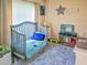 Cozy bedroom with crib, soft rug, and play kitchen at 15207 Taralane Ave, Brooksville, FL 34604