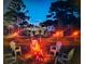 A glowing fire pit encircled by Adirondack chairs nestled within a fenced yard at 15207 Taralane Ave, Brooksville, FL 34604