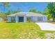 Charming one-story home featuring a well-manicured lawn and a long driveway leading to the welcoming entrance at 15207 Taralane Ave, Brooksville, FL 34604