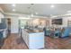 Open concept kitchen with granite island, white cabinetry and stainless appliances, flows into the living and dining area at 15207 Taralane Ave, Brooksville, FL 34604
