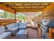 Beautiful outdoor living space, featuring a built-in grill and comfortable seating under a shaded awning at 15207 Taralane Ave, Brooksville, FL 34604