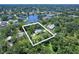 Aerial view of home that features a large lot, a screened pool, and waterfront views at 1670 Fox Rd, Clearwater, FL 33764