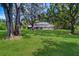 Large backyard featuring mature trees and a screened-in pool enclosure at 1670 Fox Rd, Clearwater, FL 33764