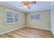 Bedroom with ceiling fan, hardwood floors, and white trim windows and baseboards at 1670 Fox Rd, Clearwater, FL 33764