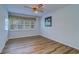 Well-lit bedroom with wood floors, a ceiling fan, and a window with charming curtains for a cozy space at 1670 Fox Rd, Clearwater, FL 33764