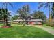 Charming two-story home featuring brick accents, mature trees, a well-manicured lawn, and circular driveway at 1670 Fox Rd, Clearwater, FL 33764