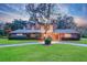 Charming two-story home featuring brick accents, a well-manicured lawn, mature landscaping, and a circular driveway at 1670 Fox Rd, Clearwater, FL 33764