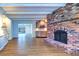 Open concept living room with brick fireplace and new flooring, seamlessly connecting living spaces at 1670 Fox Rd, Clearwater, FL 33764