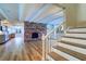 Open floor plan with wood floors, brick fireplace and staircase at 1670 Fox Rd, Clearwater, FL 33764