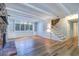 Spacious living room with wood floors, a brick fireplace, and bright windows with built in shelving at 1670 Fox Rd, Clearwater, FL 33764