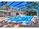 A screened in pool area features a jacuzzi, lounging area, and pristine blue water for outdoor enjoyment at 1670 Fox Rd, Clearwater, FL 33764