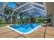 A screened in pool surrounded by lush green grass and trees for luxurious outdoor relaxation at 1670 Fox Rd, Clearwater, FL 33764