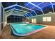 A view of the private screened-in pool featuring a bright blue pool and ample space for outdoor seating at 1670 Fox Rd, Clearwater, FL 33764