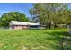 The fenced-in backyard provides plenty of space with mature shade trees and outbuildings at 17801 Simmons Rd, Lutz, FL 33548