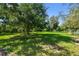 A large open backyard provides a serene view of lush green grass and mature trees at 17801 Simmons Rd, Lutz, FL 33548