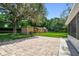 Private backyard with brick patio, storage sheds, and a spacious lawn, perfect for outdoor activities at 17801 Simmons Rd, Lutz, FL 33548